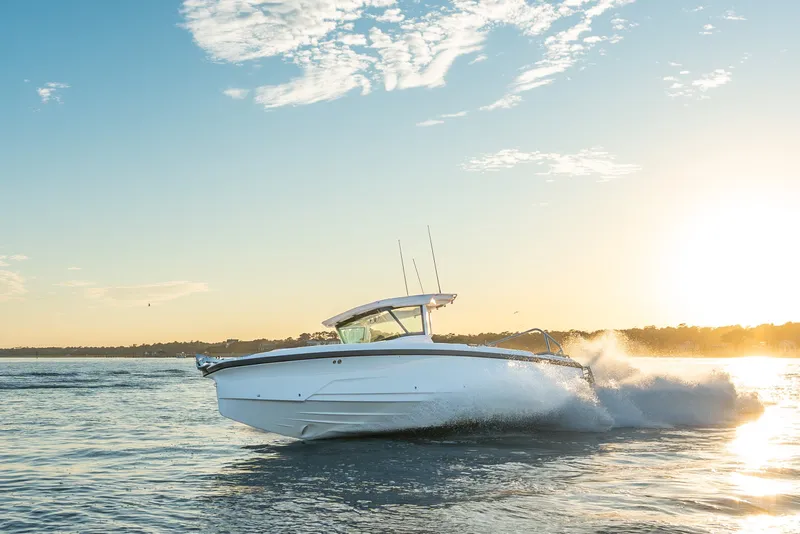 Slide: The Image of 2026 Axopar 29 CCX boat cruising at sunset on open water. - 22