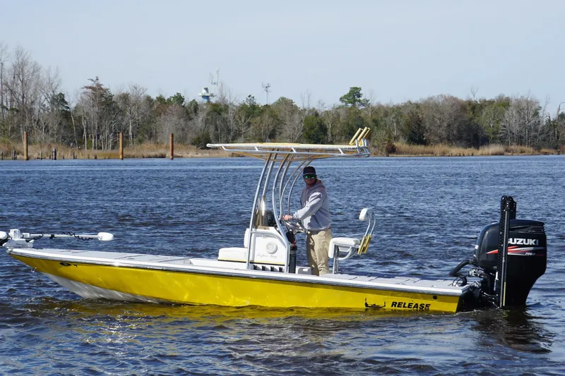 The Image of Yellow 2008 Release Tarpon Bay boat with Suzuki engine on a calm river. - 1