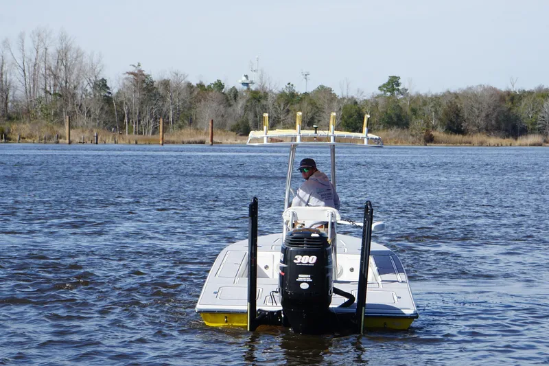 Slide: The Image of 2008 Release Tarpon Bay boat on a calm river with trees in the background. - 3