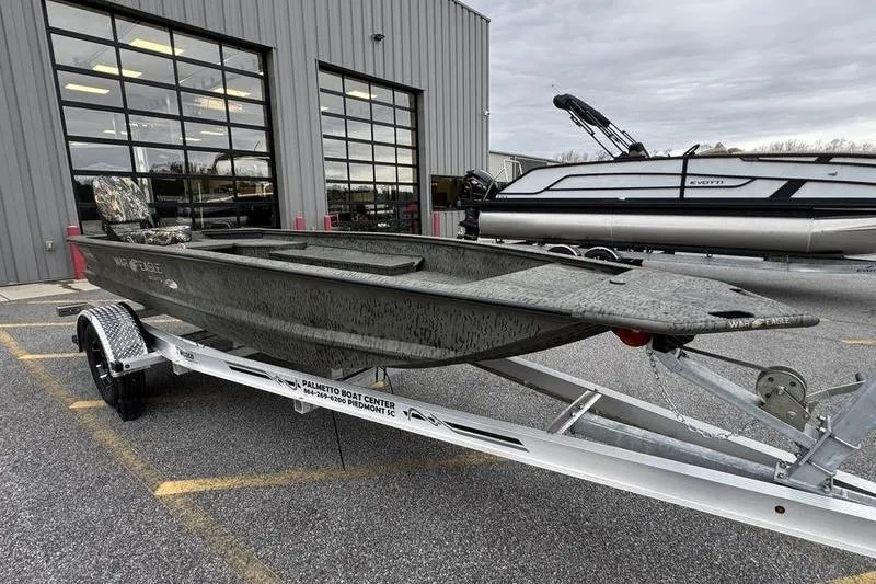 Slide: The Image of 2026 War Eagle 750 Gladiator boat on trailer outside dealership. - 1