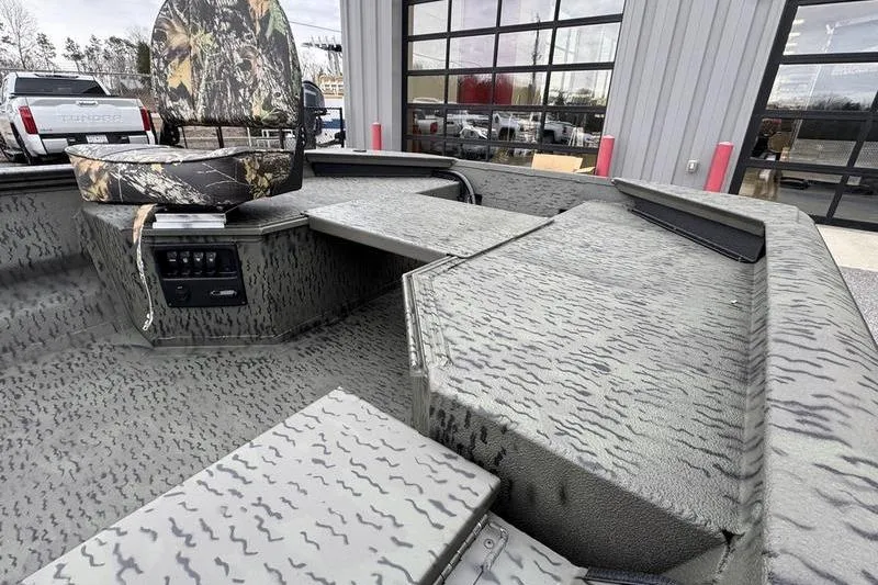 Slide: The Image of 2026 War Eagle 750 Gladiator boat interior with camo seating and textured flooring. - 10