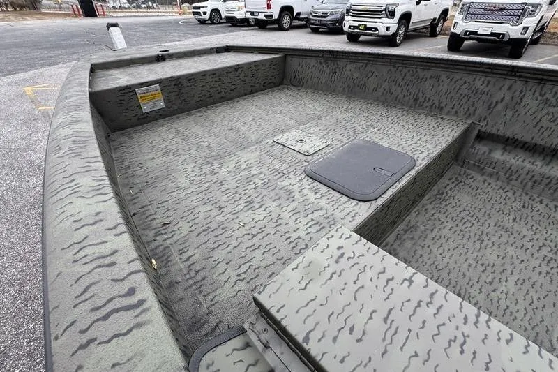 Slide: The Image of 2026 War Eagle 750 Gladiator boat interior with camouflage pattern in a parking lot. - 13