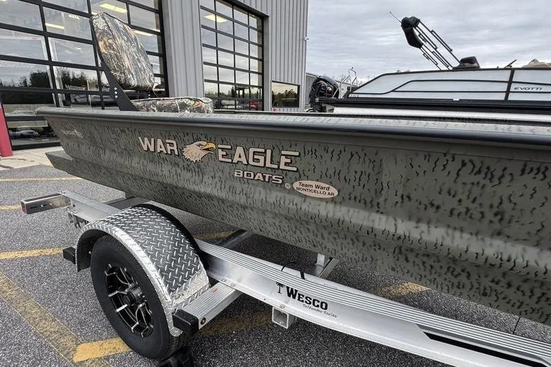 Slide: The Image of 2026 War Eagle 750 Gladiator boat on trailer outside a building. - 3