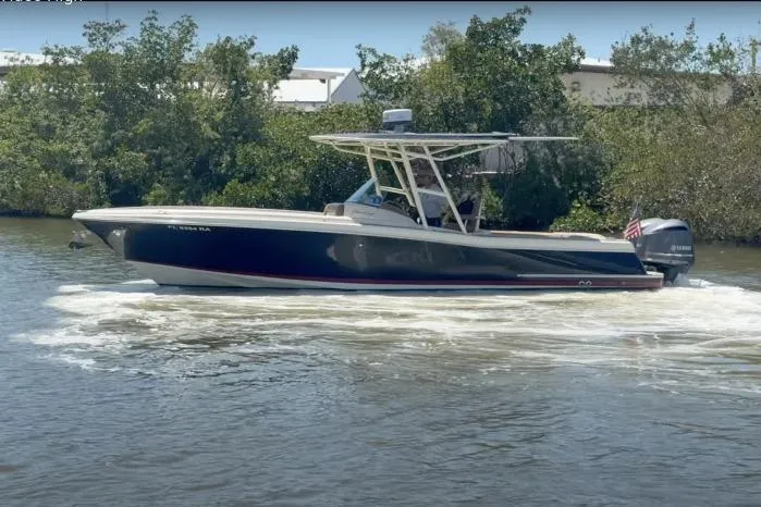 The Image of 2012 Chris-Craft Catalina 29 boat cruising on a river with lush greenery in the background. - 0