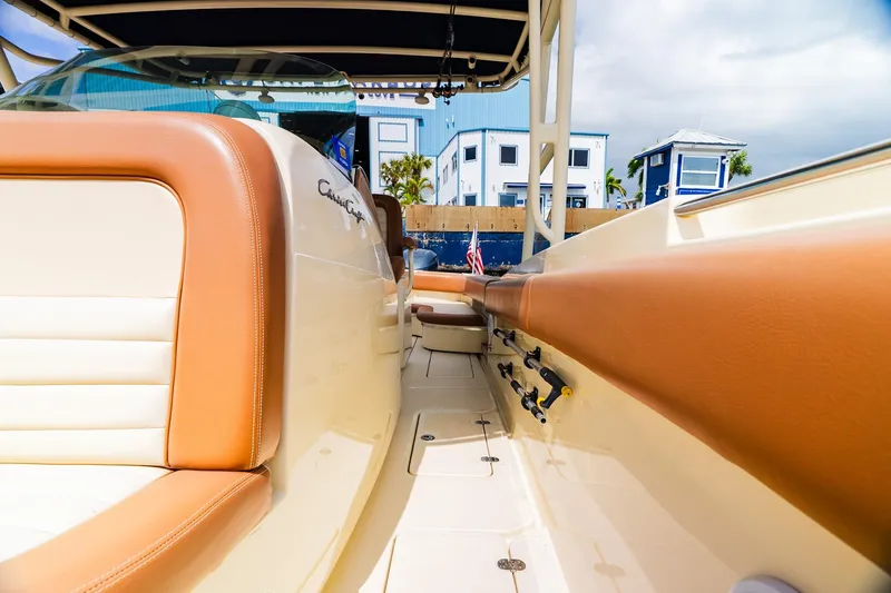 Slide: The Image of 2012 Chris-Craft Catalina 29 Sun Tender interior with tan leather seating and fishing rod holders. - 19