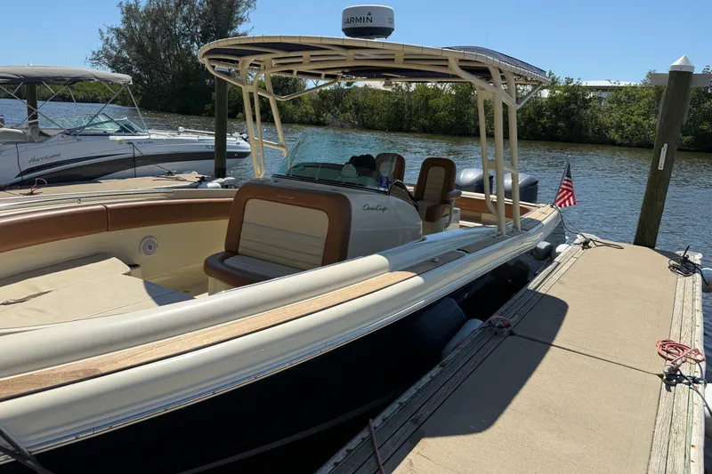 Slide: The Image of 2012 Chris-Craft Catalina 29 boat docked by the water, featuring elegant design and American flag. - 2