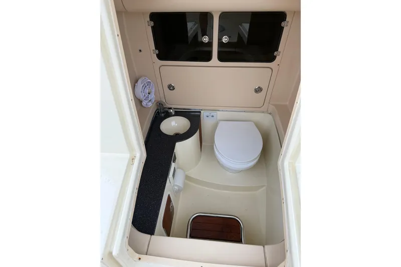 Slide: The Image of 2012 Chris-Craft Catalina 29 boat bathroom with toilet, sink, and storage cabinets. - 39