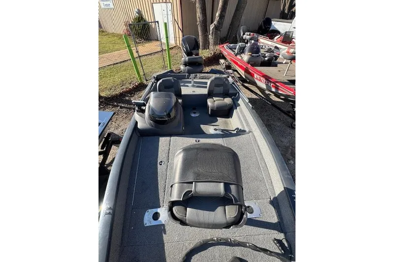 Slide: The Image of 2019 Tracker Pro Team 175 TF fishing boat with seating and storage, parked outdoors. - 5