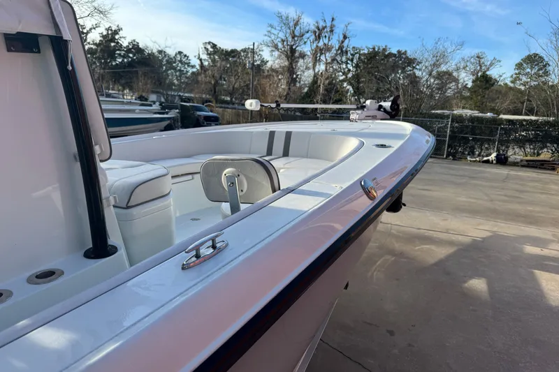 Slide: The Image of 2023 Contender 25 Bay boat, sleek design, white interior, parked outdoors. - 12