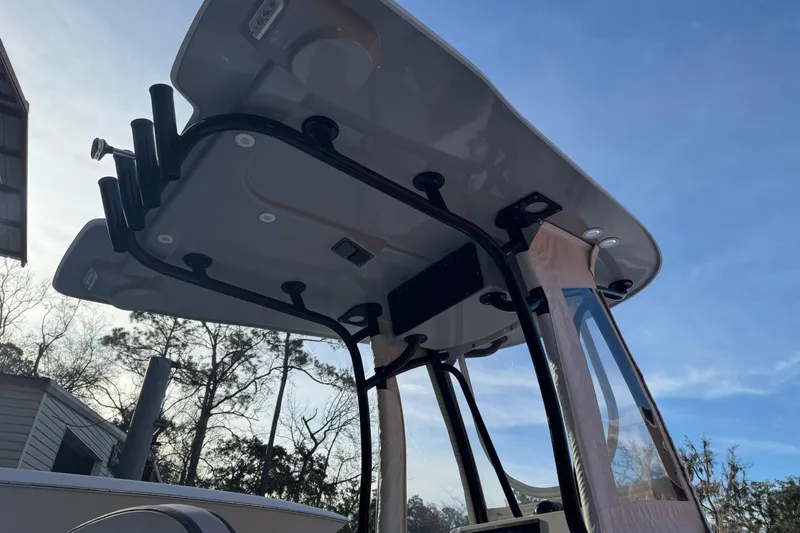 Slide: The Image of 2023 Contender 25 Bay boat with T-top and rod holders against a clear sky. - 15