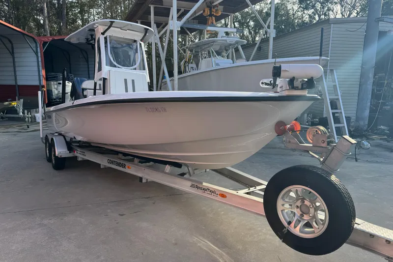 Slide: The Image of 2023 Contender 25 Bay boat on trailer in a storage facility. - 2