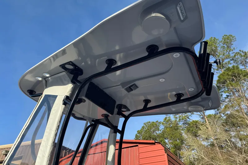 Slide: The Image of 2023 Contender 25 Bay boat T-top with rod holders and LED lights, under clear blue sky. - 20