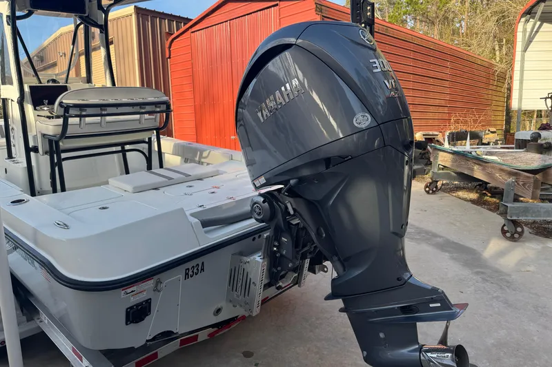 Slide: The Image of 2023 Contender 25 Bay boat with Yamaha 300 outboard motor in a storage area. - 21