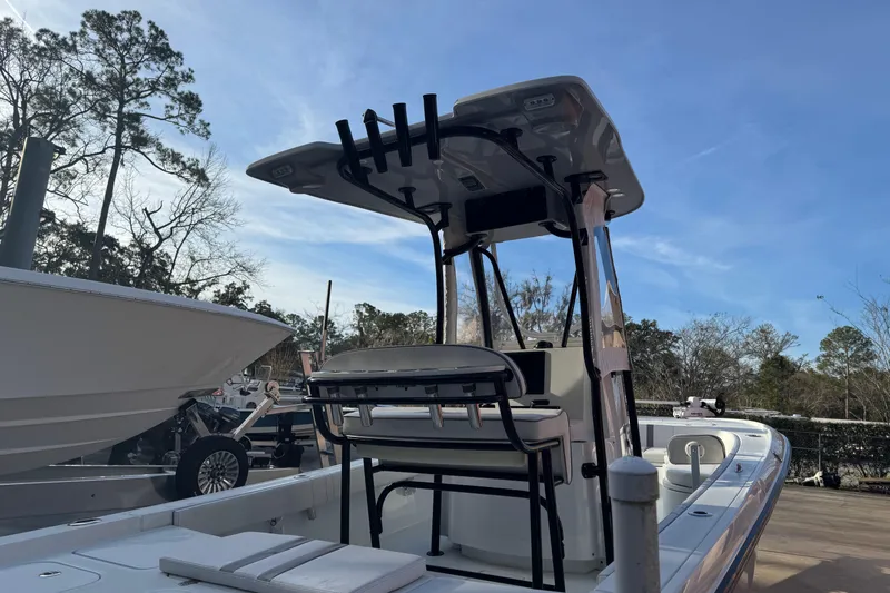 Slide: The Image of 2023 Contender 25 Bay boat with T-top, parked outdoors under clear sky. - 23