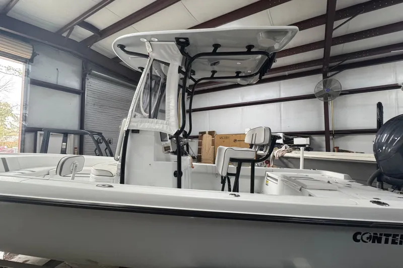 Slide: The Image of 2023 Contender 25 Bay boat in a warehouse, showcasing sleek design and modern features. - 24