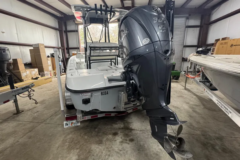 Slide: The Image of 2023 Contender 25 Bay boat with Yamaha outboard motor in a storage facility. - 25