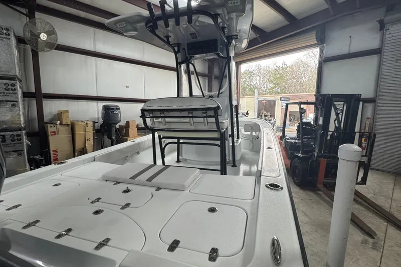 Slide: The Image of 2023 Contender 25 Bay boat in warehouse, featuring spacious deck and modern design. - 26
