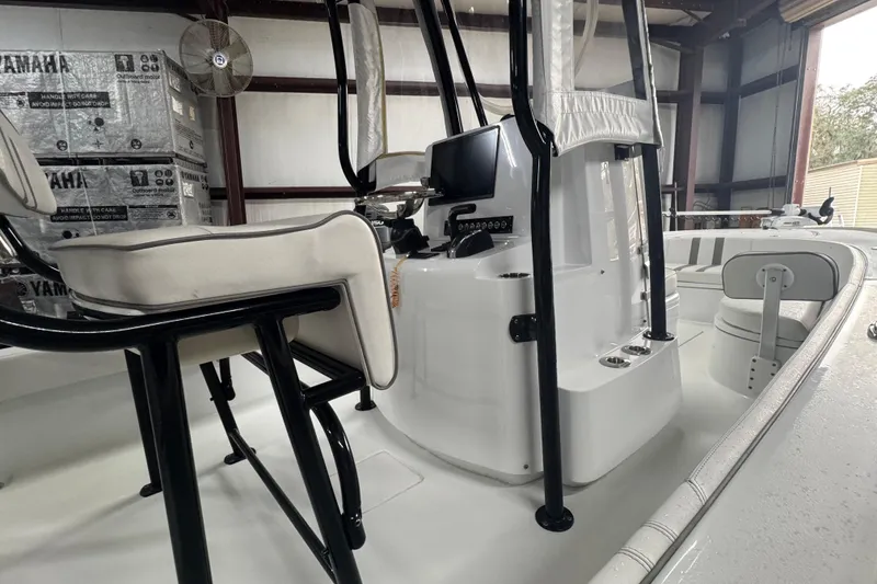 Slide: The Image of 2023 Contender 25 Bay boat interior with console and seating in a warehouse. - 30