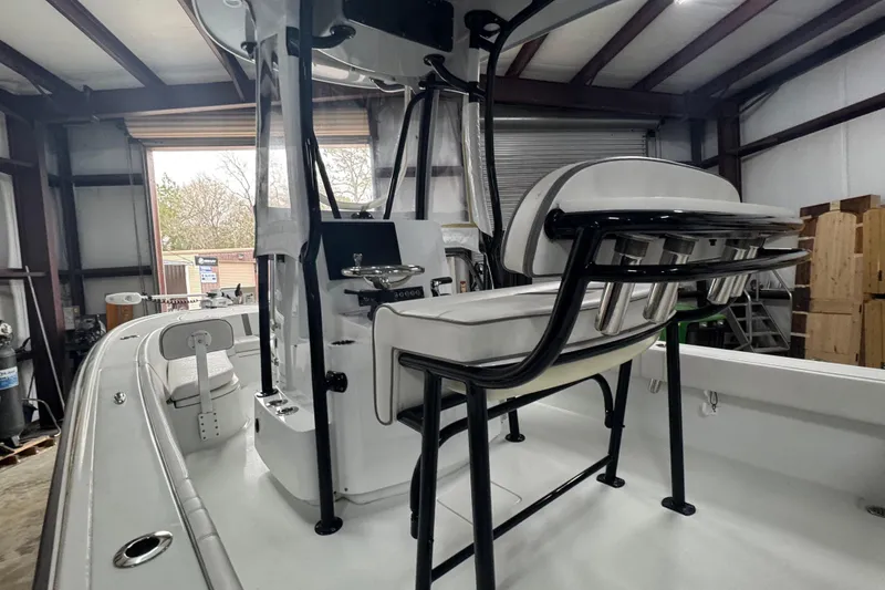 Slide: The Image of 2023 Contender 25 Bay boat interior with seating and console in a warehouse. - 31