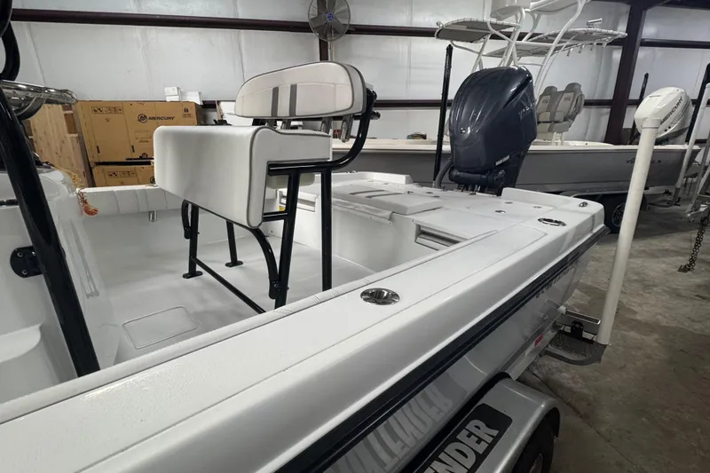 Slide: The Image of 2023 Contender 25 Bay boat in a warehouse, featuring a sleek design and powerful engine. - 8