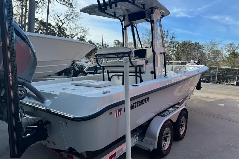 Slide: The Image of 2023 Contender 25 Bay boat on trailer, parked outdoors, showcasing sleek design and modern features. - 9
