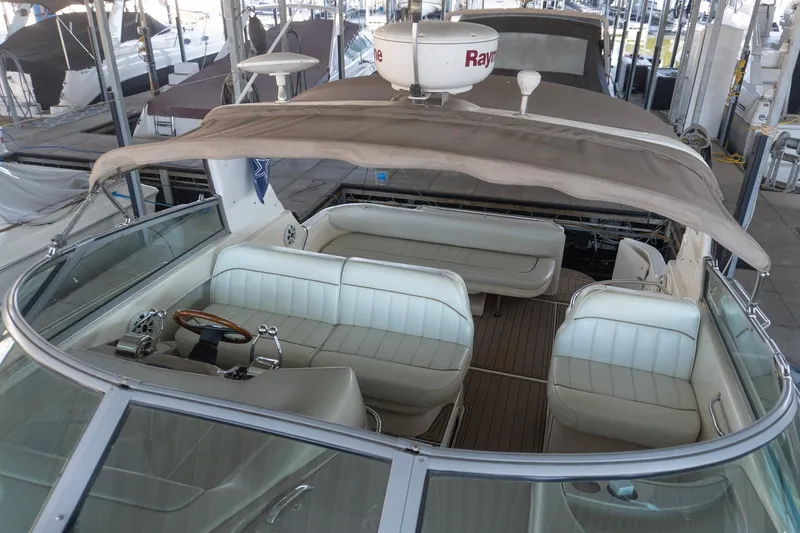 Slide: The Image of 1998 Sea Ray Sundancer 330 interior with white seating and wooden steering wheel. - 12