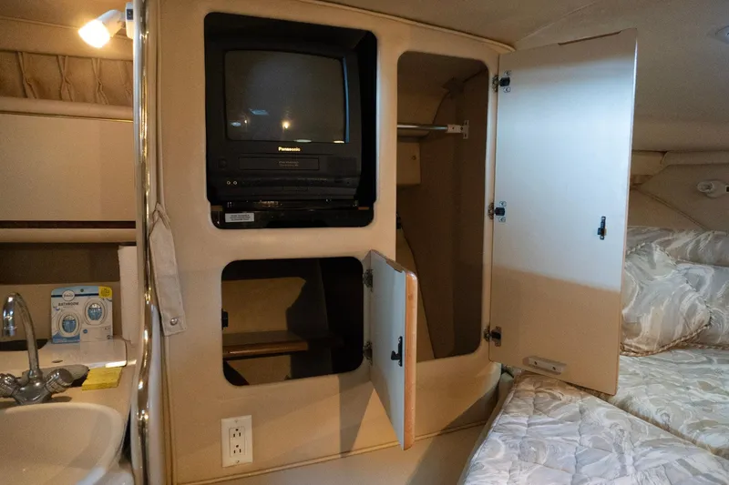 Slide: The Image of 1998 Sea Ray Sundancer 330 cabin interior with TV, storage, and sink. - 17