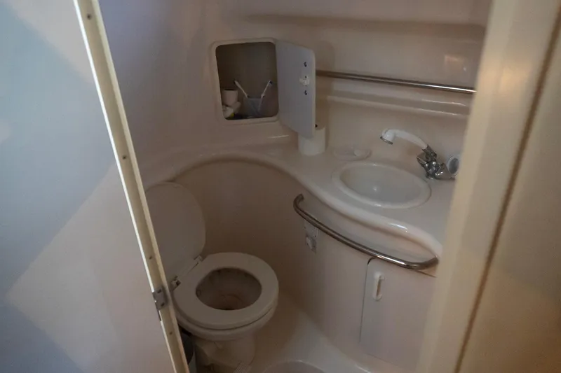 Slide: The Image of 1998 Sea Ray Sundancer 330 bathroom with toilet, sink, and storage cabinet. - 24