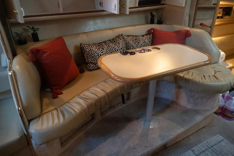 Slide: The Image of 1998 Sea Ray Sundancer 330 interior with cozy seating and decorative pillows. - 28