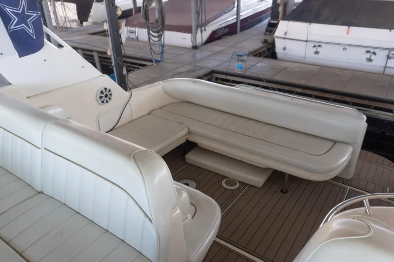 Slide: The Image of 1998 Sea Ray Sundancer 330 boat interior with white seating and wood flooring. - 3