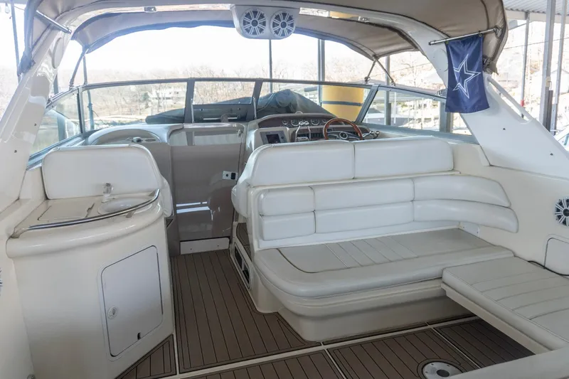 Slide: The Image of 1998 Sea Ray Sundancer 330 interior with white seating and helm, docked in marina. - 4