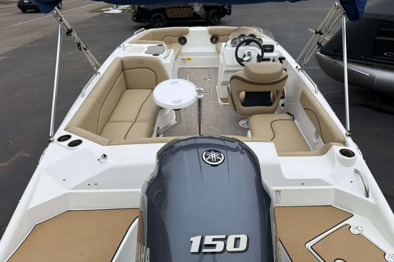 Slide: The Image of 2020 NauticStar 203 SC boat interior with Yamaha 150 engine, beige seating, and steering console. - 3