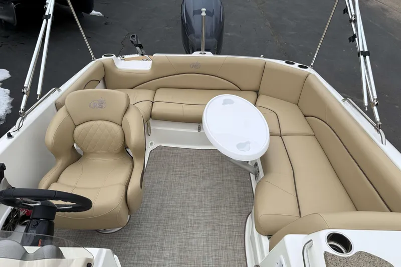 Slide: The Image of 2020 NauticStar 203 SC boat interior with beige seating and a small table. - 5