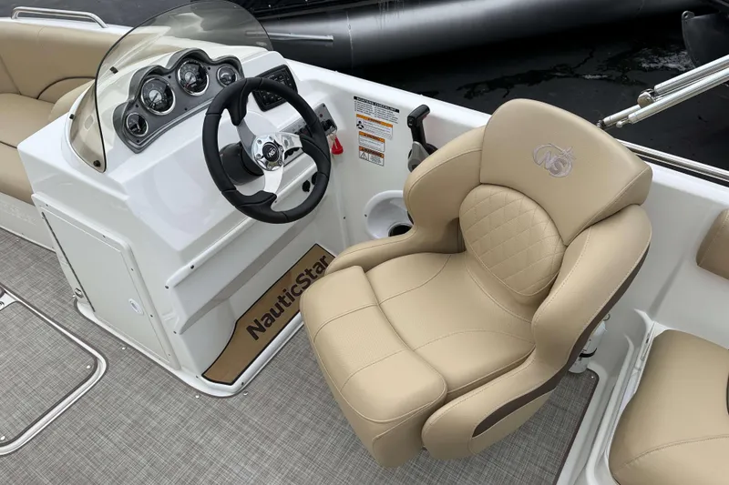 Slide: The Image of 2020 NauticStar 203 SC boat interior with steering wheel and beige captain's chair. - 6