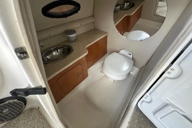 Slide: The Image of 2007 Chaparral Sunesta 254 boat bathroom with sink, toilet, and mirror. - 14