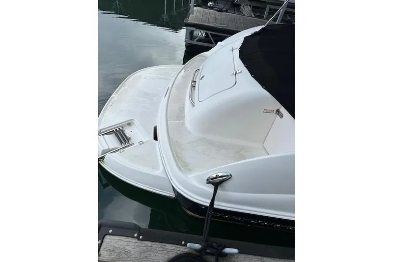 Slide: The Image of 2007 Chaparral Sunesta 254 boat docked, featuring a swim platform and ladder. - 8