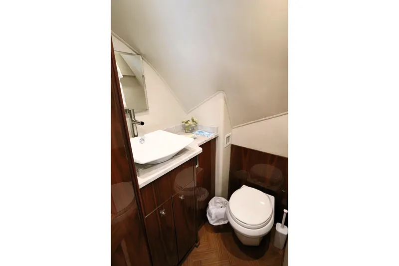 Slide: The Image of Luxurious bathroom in 2017 Viking 80 Enclosed Bridge yacht with modern fixtures and wood accents. - 10