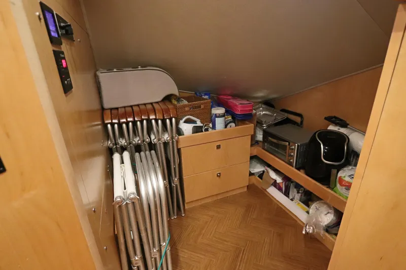 Slide: The Image of Storage area in a 2017 Viking 80 Enclosed Bridge yacht with appliances and folding chairs. - 11