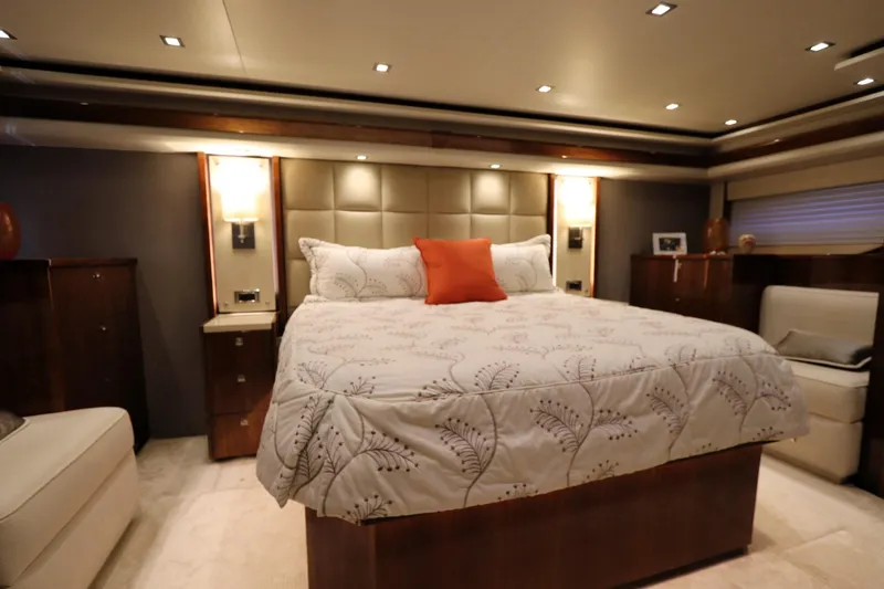 Slide: The Image of Luxurious bedroom interior of 2017 Viking 80 Enclosed Bridge yacht, featuring elegant bedding and lighting. - 12