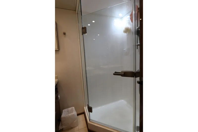 Slide: The Image of Shower area inside 2017 Viking 80 Enclosed Bridge yacht, featuring glass door and modern fixtures. - 20