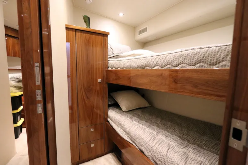 Slide: The Image of Interior of 2017 Viking 80 Enclosed Bridge with wooden bunk beds and storage. - 26