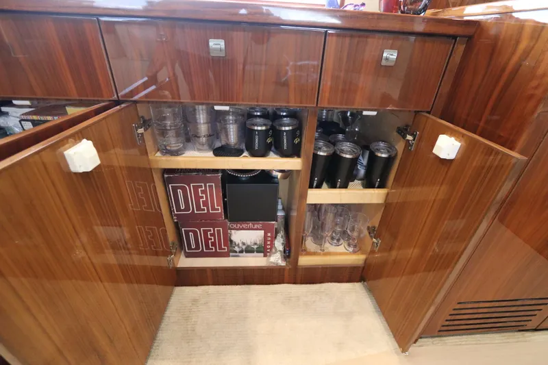 Slide: The Image of Wooden cabinet with glassware and tumblers inside a 2017 Viking 80 Enclosed Bridge yacht. - 37