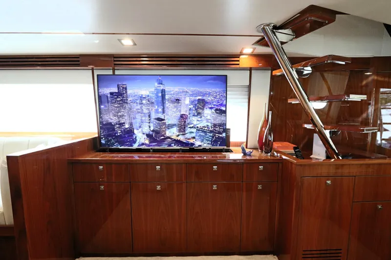 Slide: The Image of Luxurious interior of 2017 Viking 80 Enclosed Bridge yacht with modern TV and wood finish. - 38