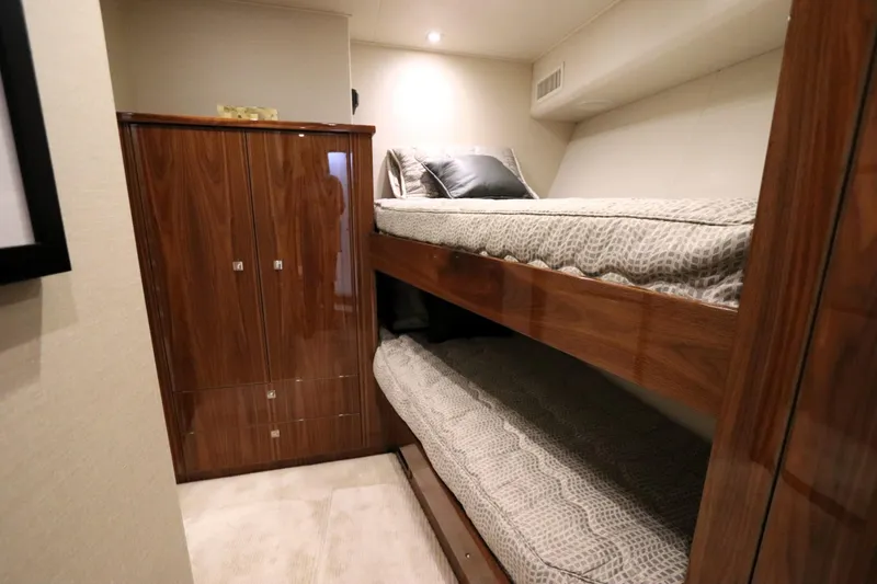 Slide: The Image of Luxurious cabin interior of 2017 Viking 80 Enclosed Bridge yacht with wooden bunk beds. - 40