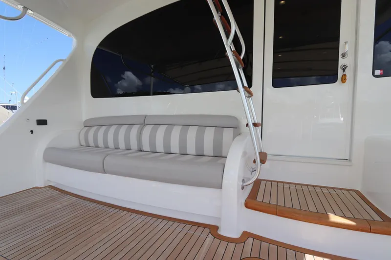 Slide: The Image of 2017 Viking 80 Enclosed Bridge yacht with striped seating and wooden deck. - 43