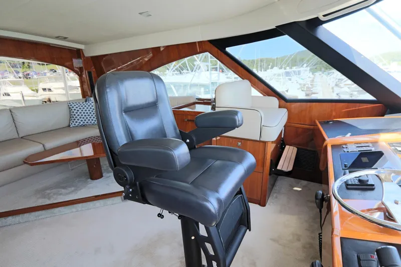 Slide: The Image of Interior of 2017 Viking 80 Enclosed Bridge yacht with captain's chair and helm. - 51