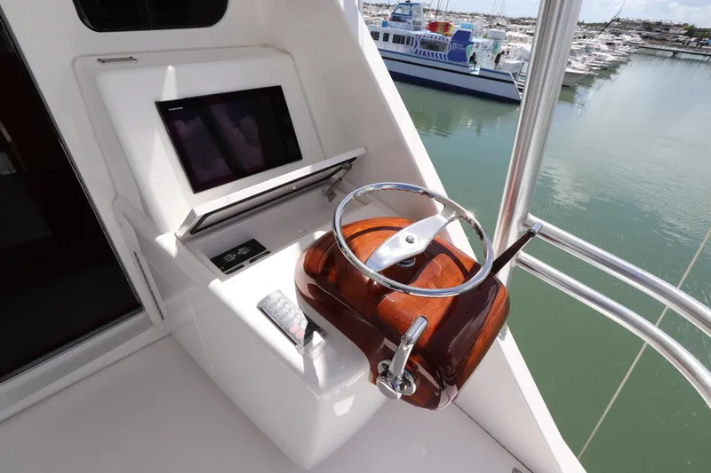 Slide: The Image of 2017 Viking 80 Enclosed Bridge helm with steering wheel and control panel. - 54