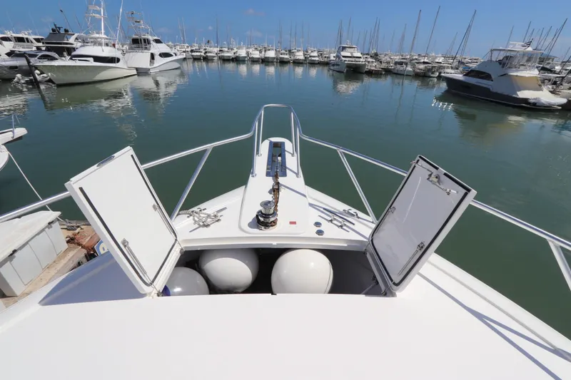 Slide: The Image of 2017 Viking 80 Enclosed Bridge yacht docked in a marina, open hatches visible. - 62