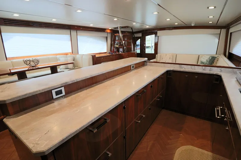 Slide: The Image of Luxurious interior of 2017 Viking 80 Enclosed Bridge yacht with modern kitchen and seating area. - 9