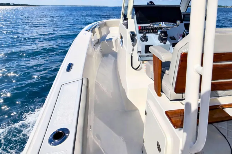 Slide: The Image of 2025 Pursuit S 288 Sport boat cruising on open water, featuring sleek design and modern controls. - 10